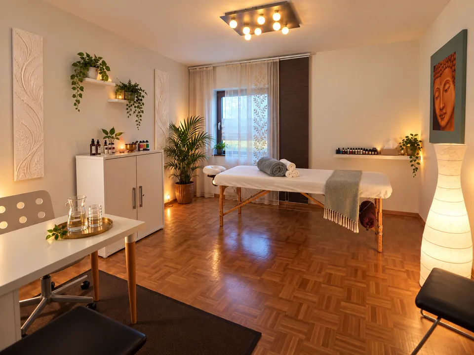 Der Behandlungsraum mit Massageliege, Pflanzen und Buddha-Bild